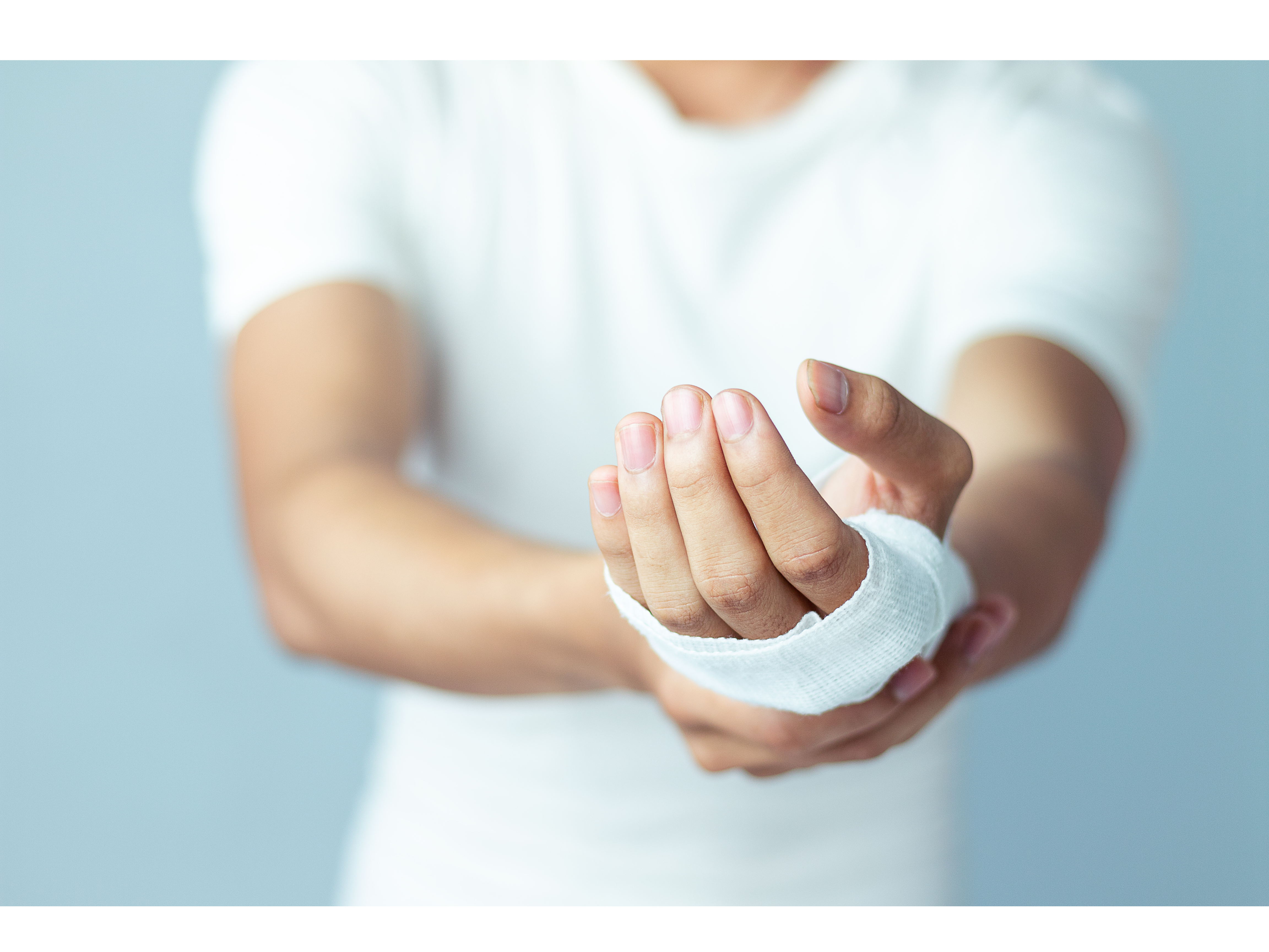 A patient displays his bandaged hand.
